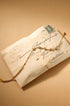 Gold geometric charm bracelet with clear stones on an antique envelope.