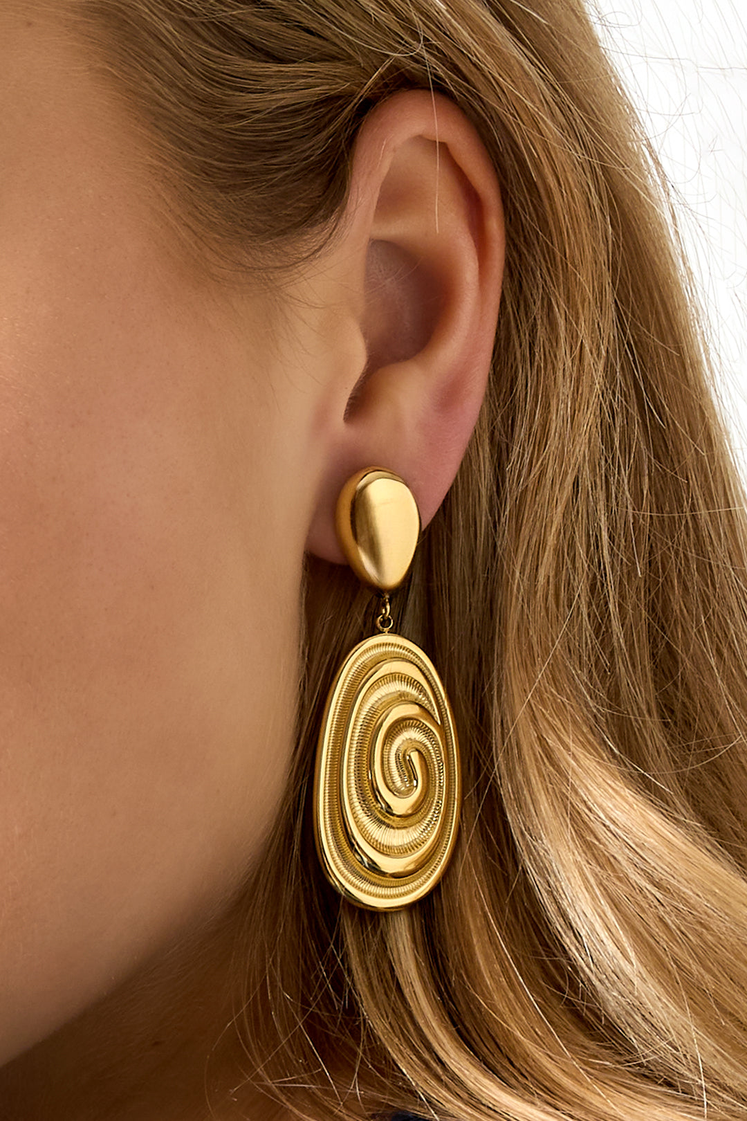 Gold irregular drop earrings with a spiral design.