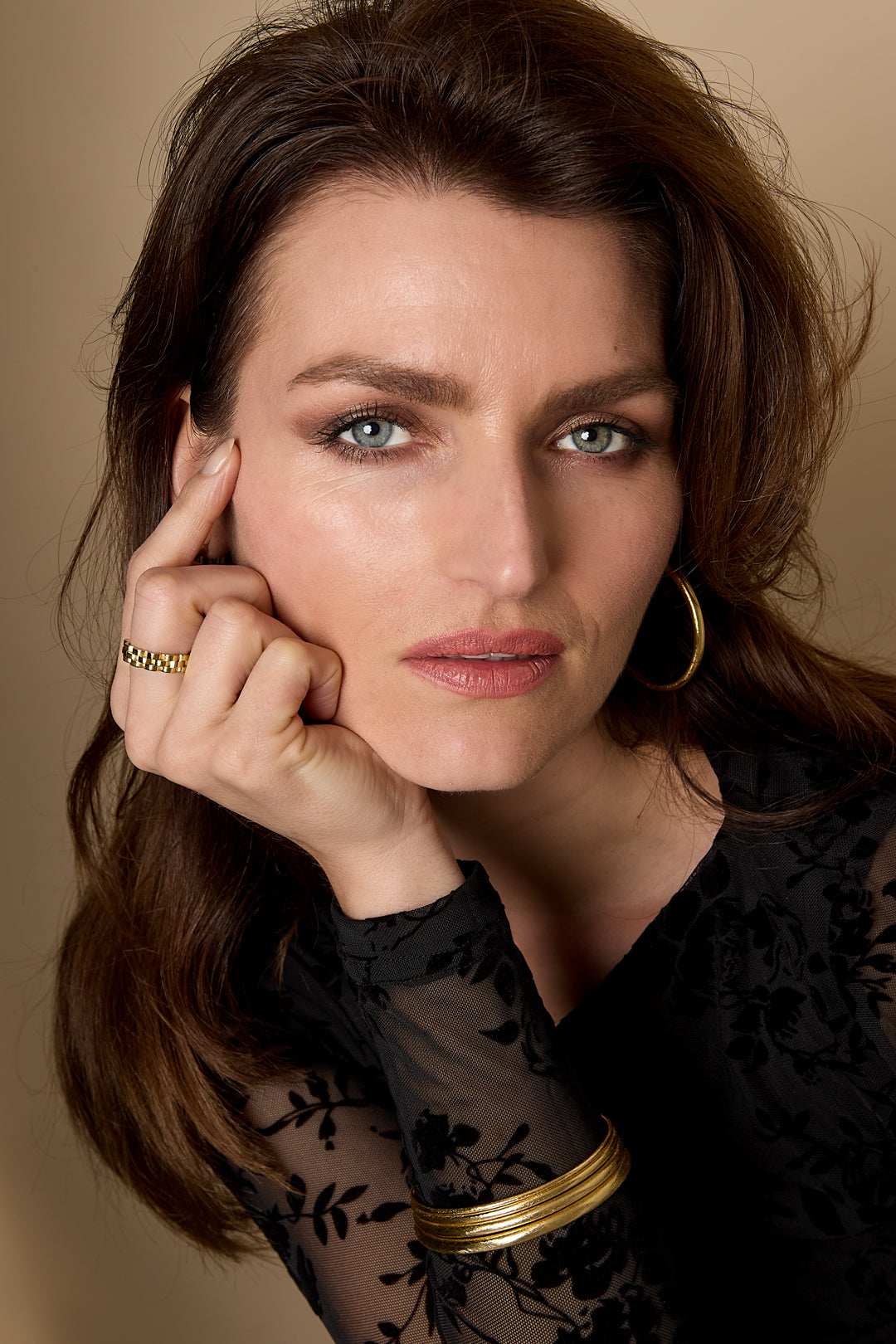 Woman wearing the Elara Bangle Bracelet, a thin gold band on her wrist.