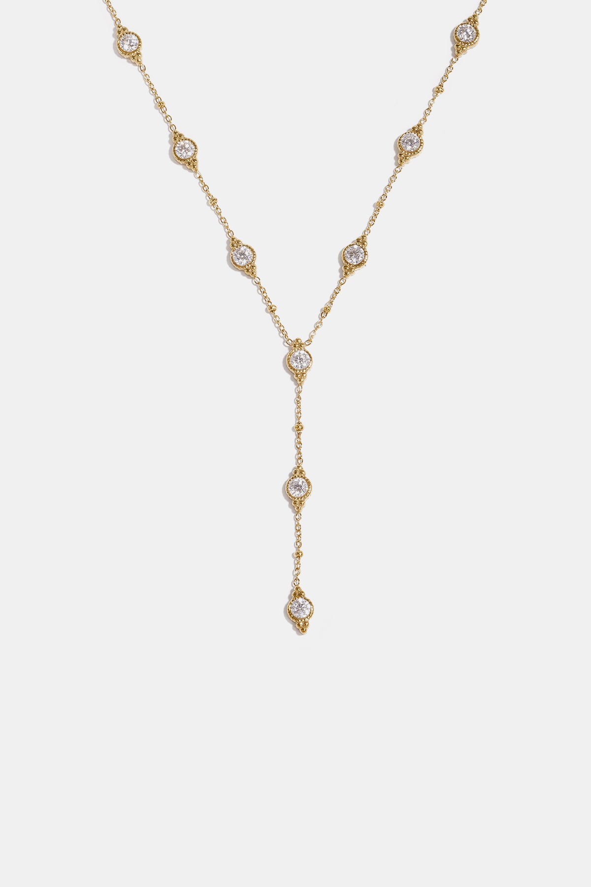 Gold Y-shaped necklace with a chain of small beads and circular pendants, each with a clear stone.