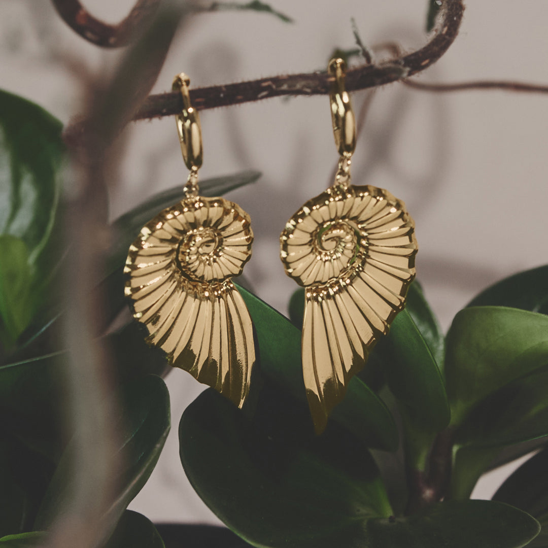Gold-plated stainless steel hoop earrings shaped like spiral shells with intricate detailing.