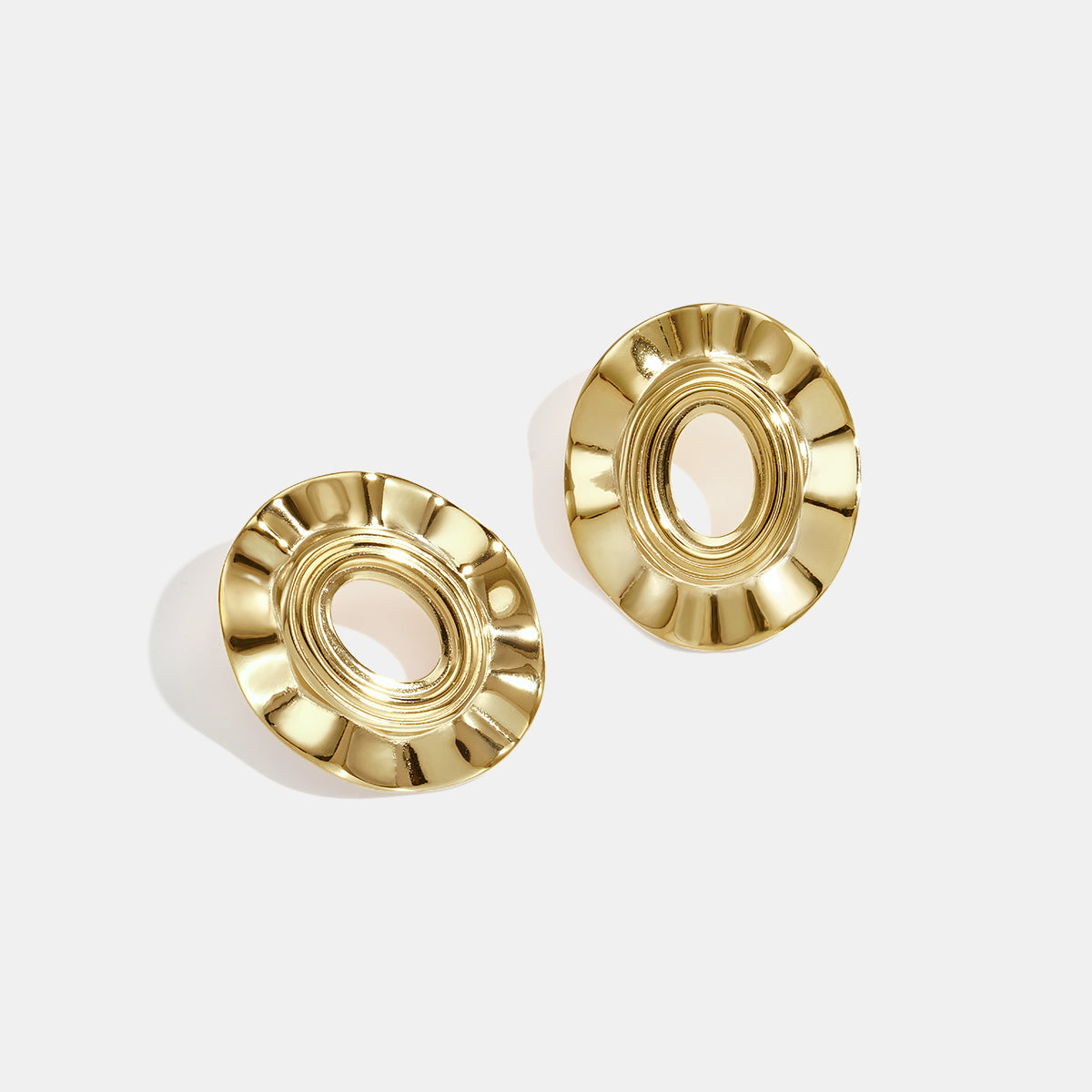 Pair of gold-plated irregular shape stud earrings with a textured, circular design.