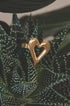 Gold heart-shaped ring resting on a succulent plant.