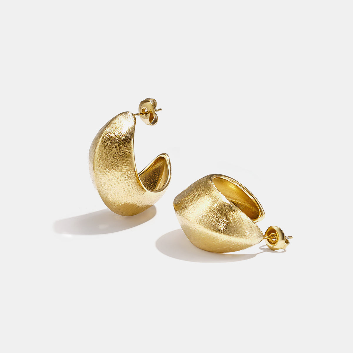 Aurelia Hoop Earrings in gold, featuring a textured, curved design.