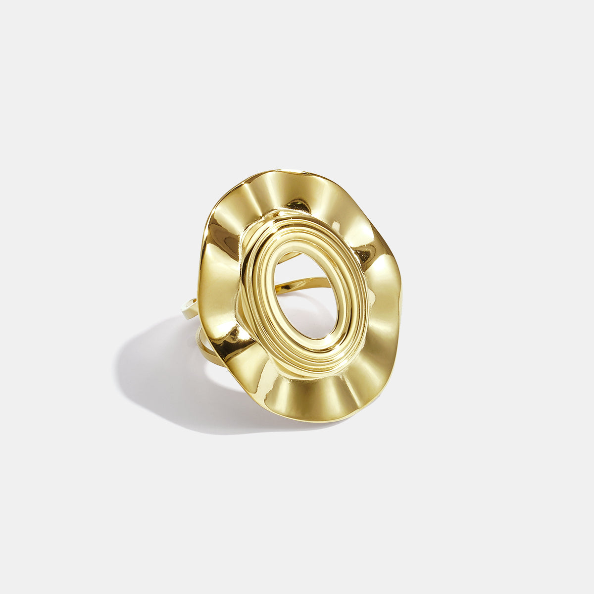 Irregular minimalist ring in gold with an oval center and wavy edges.