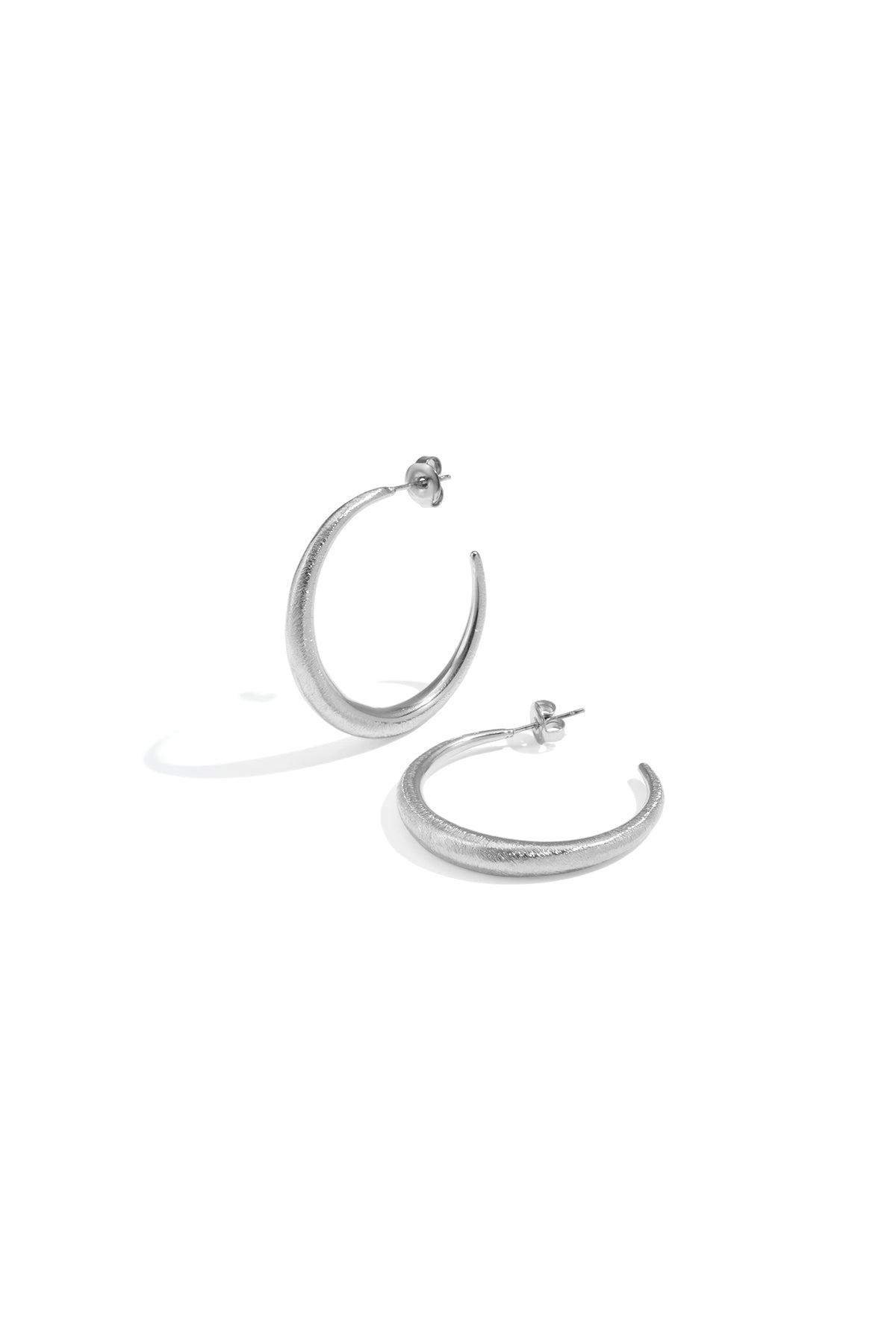 Two silver Aurelia hoop earrings with a textured finish on a white background.