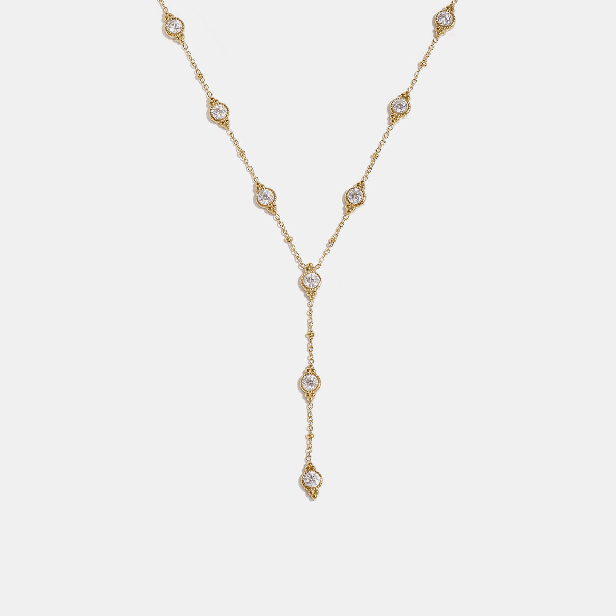 Gold Astra pendant necklace with scattered clear stones and a Y-drop chain.