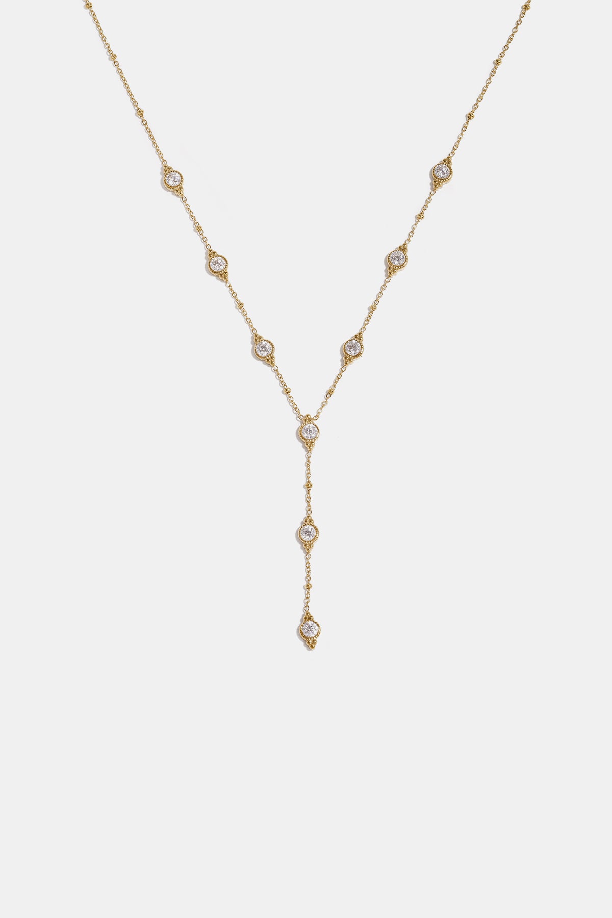 Gold Astra pendant necklace with scattered clear stones and a Y-drop chain.