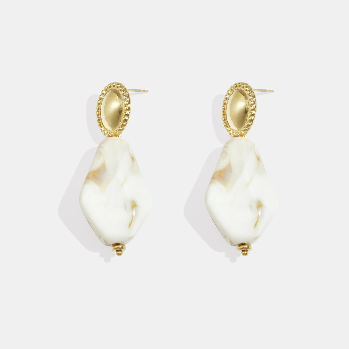 Gold stud earrings with oval textured tops and irregular white and amber marbled drop pendants.