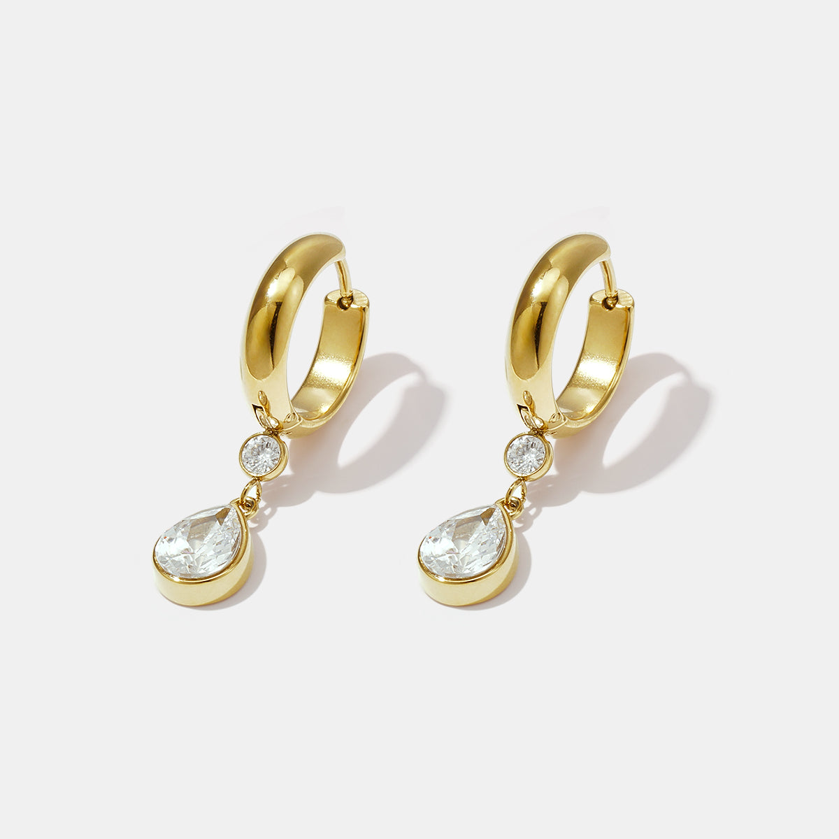 Gold hoop earrings with a pear-shaped zircon drop and a smaller round zircon above it.