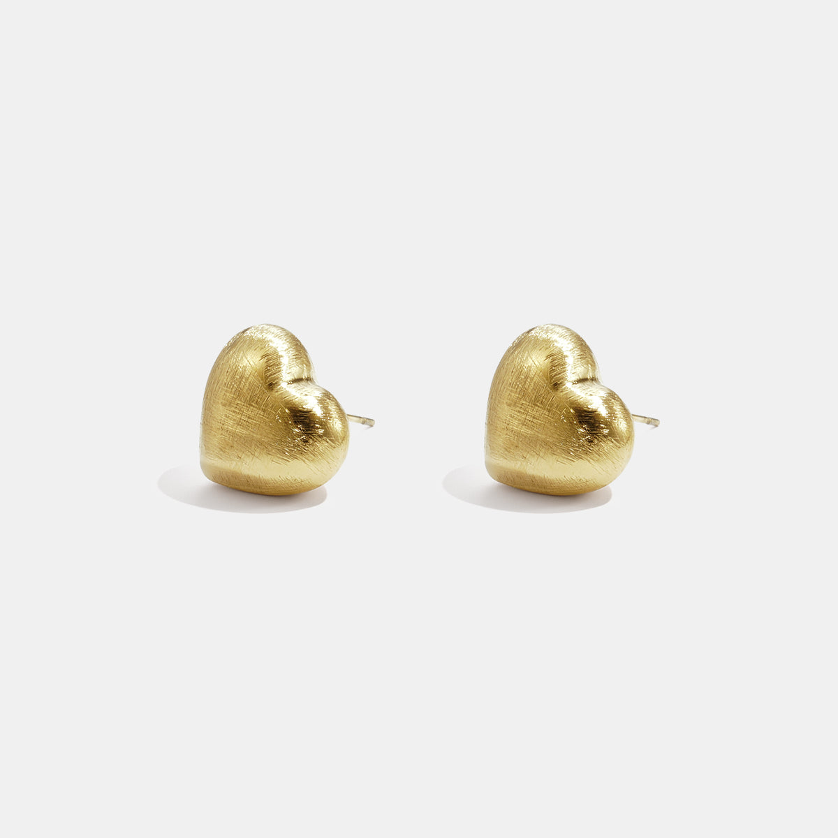 Pair of matte gold heart-shaped stud earrings with post back fastening.