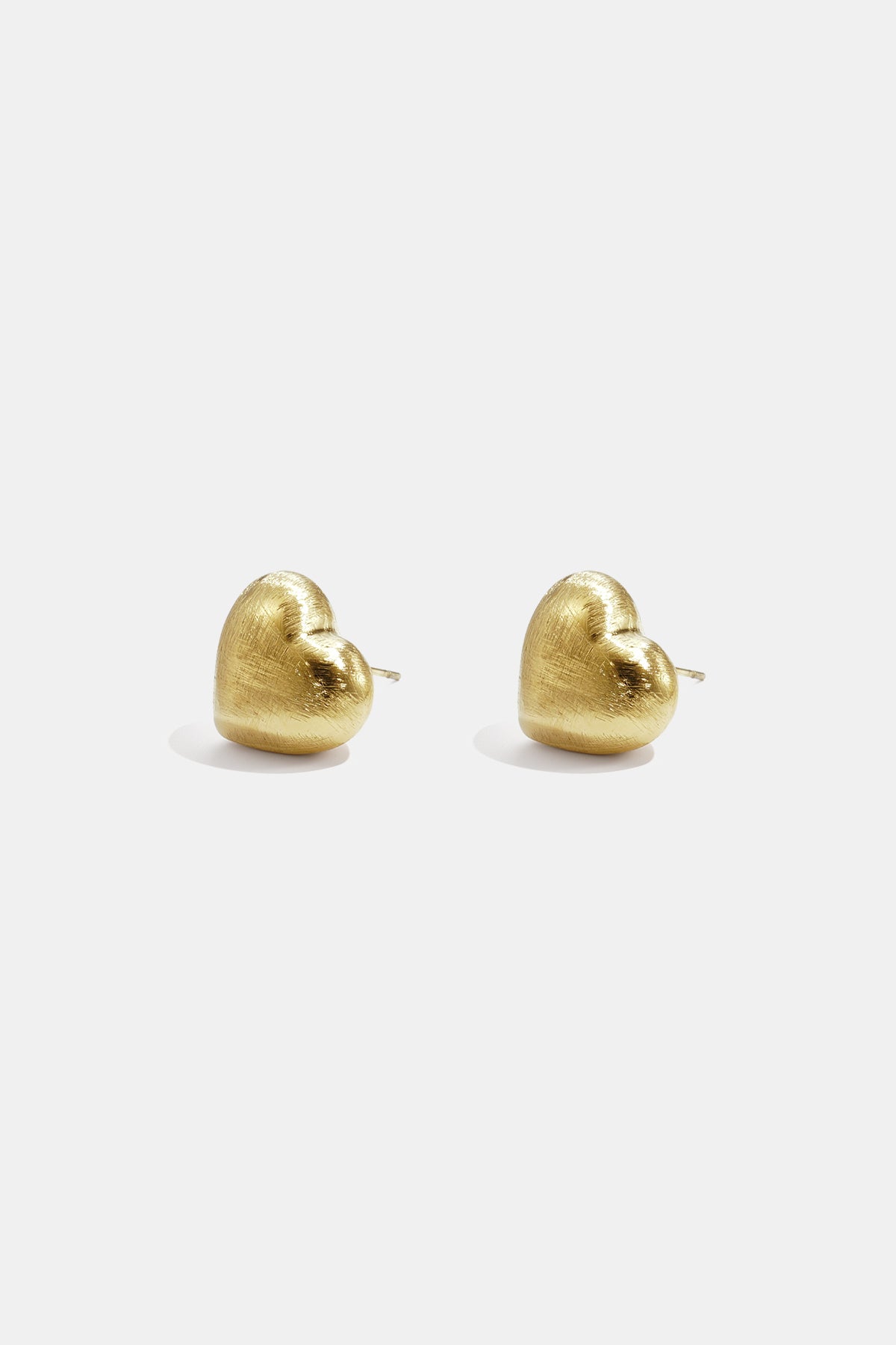 Pair of matte gold heart-shaped stud earrings with post back fastening.