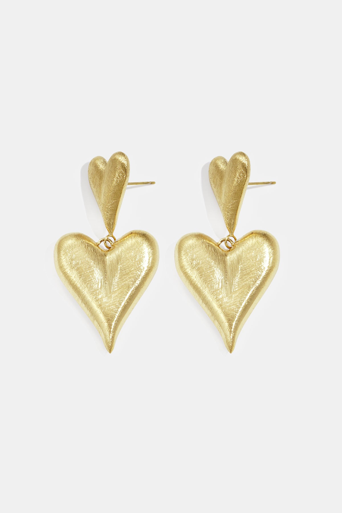 Gold heart drop earrings with a smaller heart stud and a larger dangling heart.