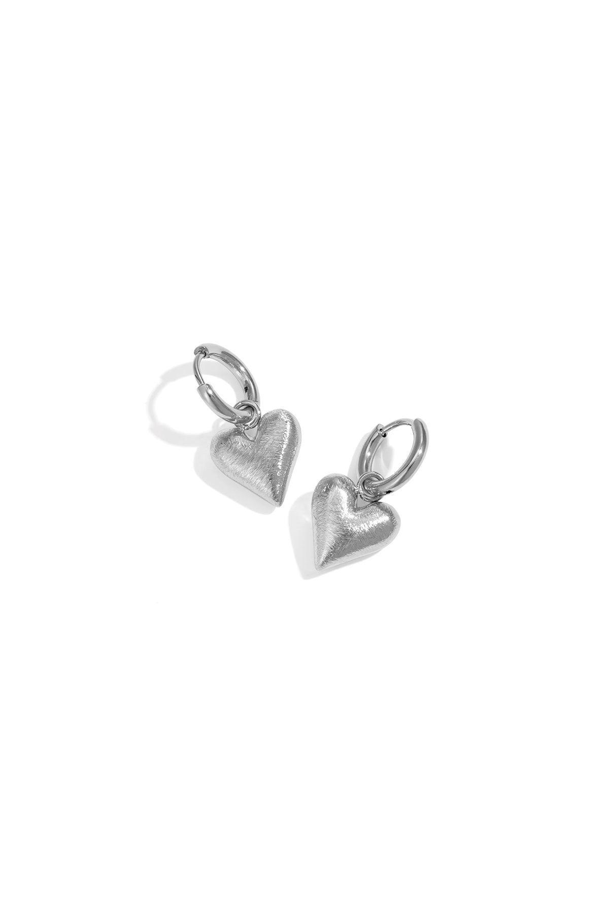 Silver heart drop earrings with a brushed finish, on a white background.