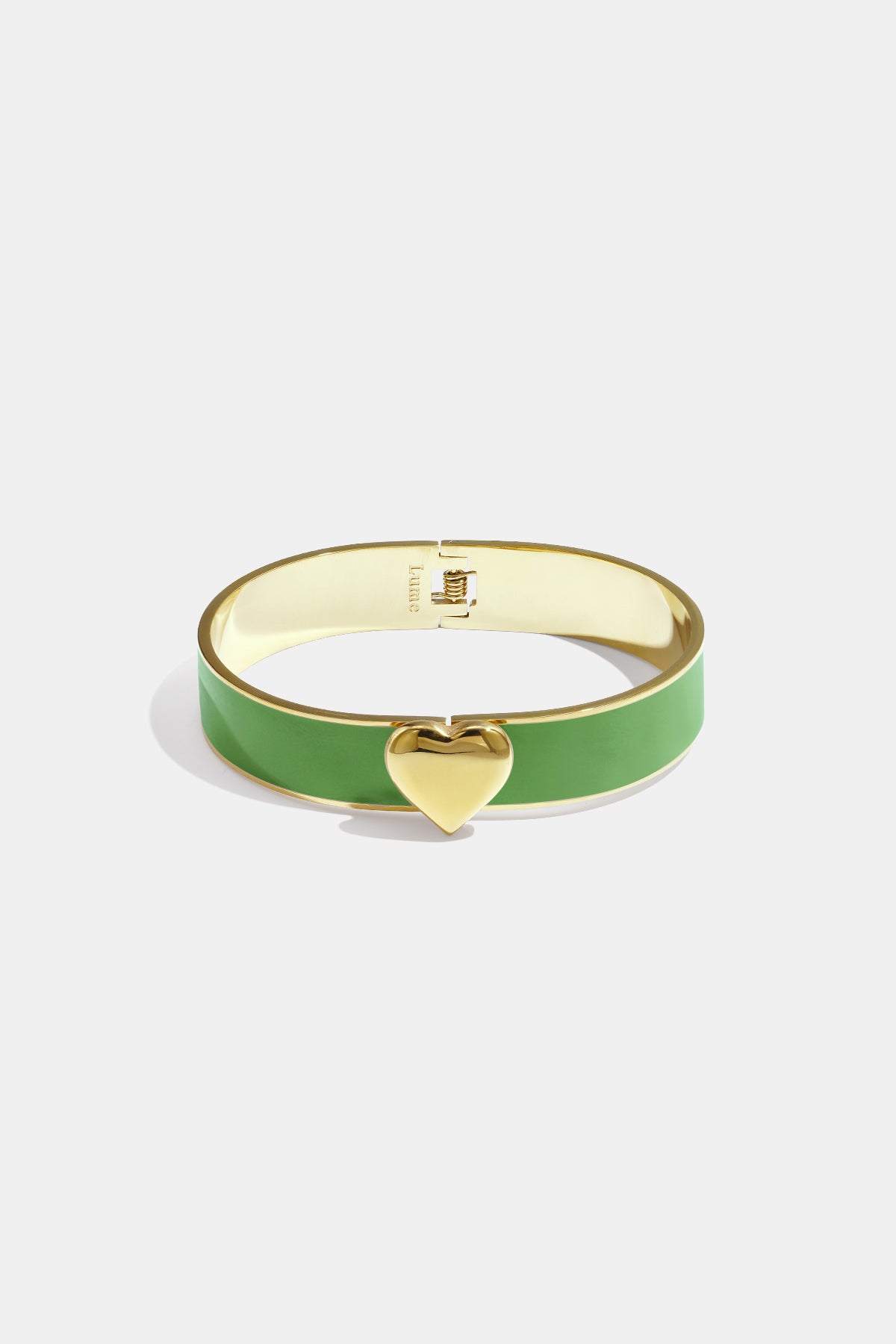 Gold bangle bracelet with a green enamel band and a gold heart charm.