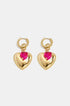 Gold heart hoop earrings with a pink heart bead accent.