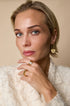 Gold-tone adjustable ring with a central marquise-cut zircon stone, worn on a woman's finger.