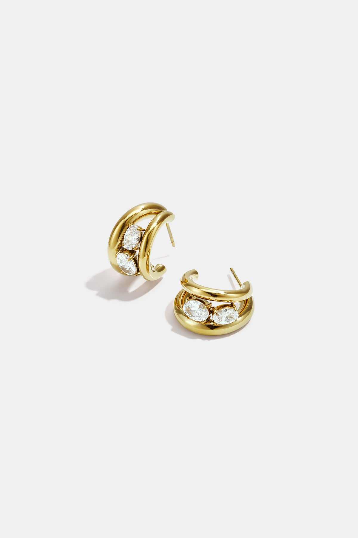 Gold hoop earrings with three clear oval stones set in each.