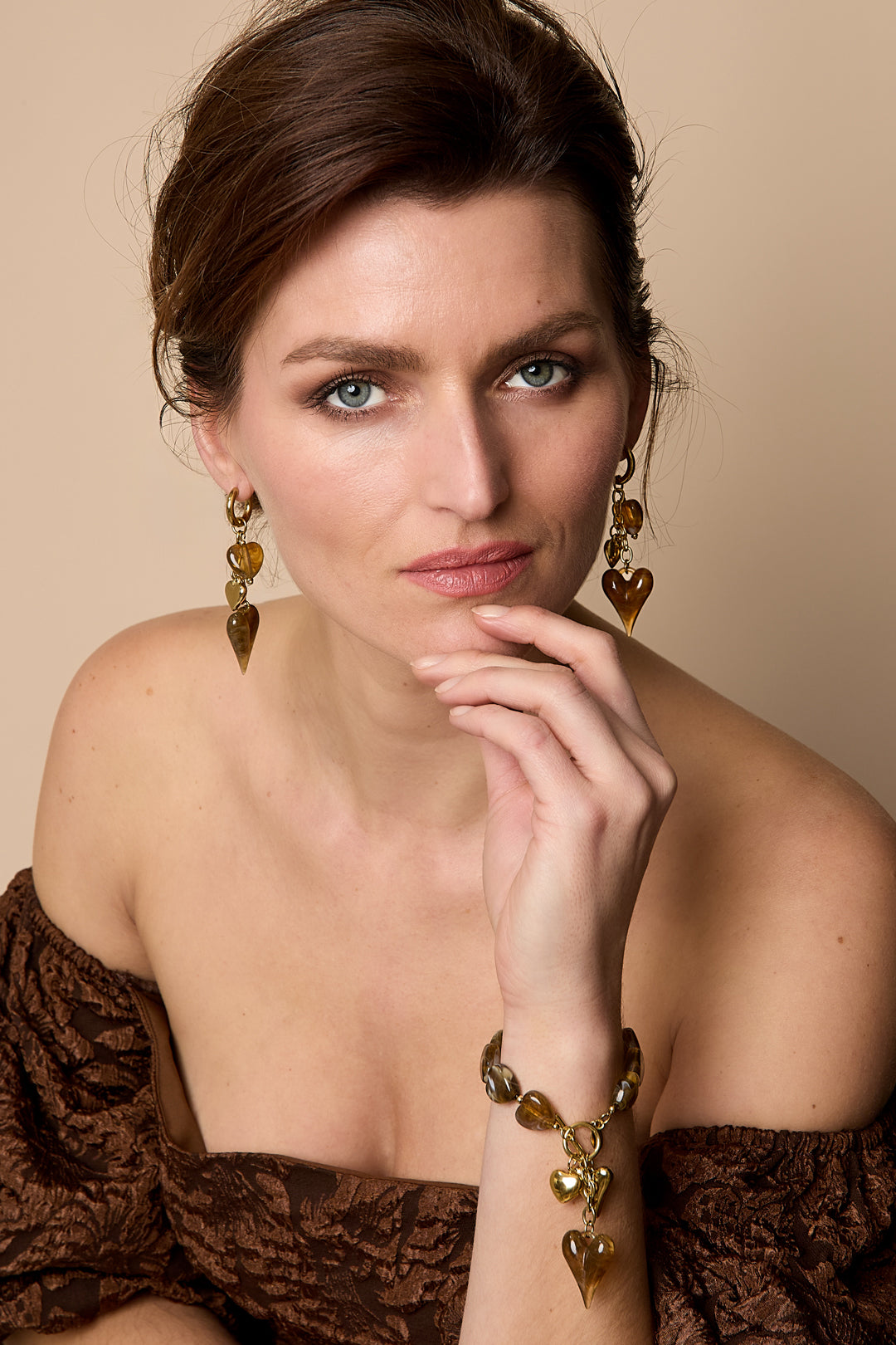 Gold-tone earrings with dangling amber-colored heart charms.
