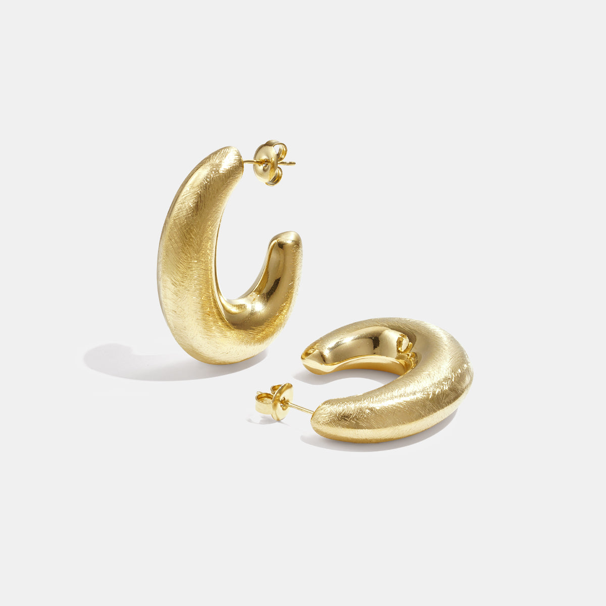 Aurelia Hoop Earrings: a pair of textured gold hoop earrings on a white background.