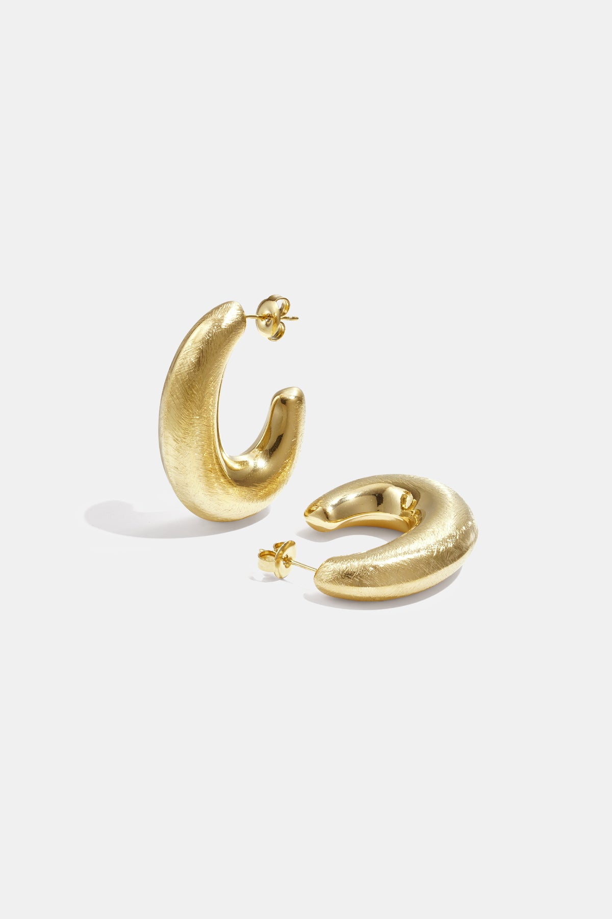 Aurelia Hoop Earrings: a pair of textured gold hoop earrings on a white background.