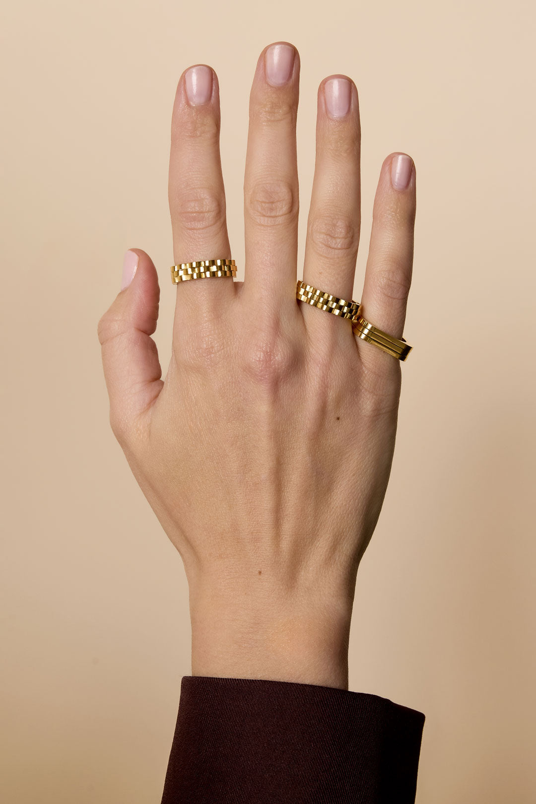 Gold-plated stainless steel ring with a minimalist rectangular design on a hand.
