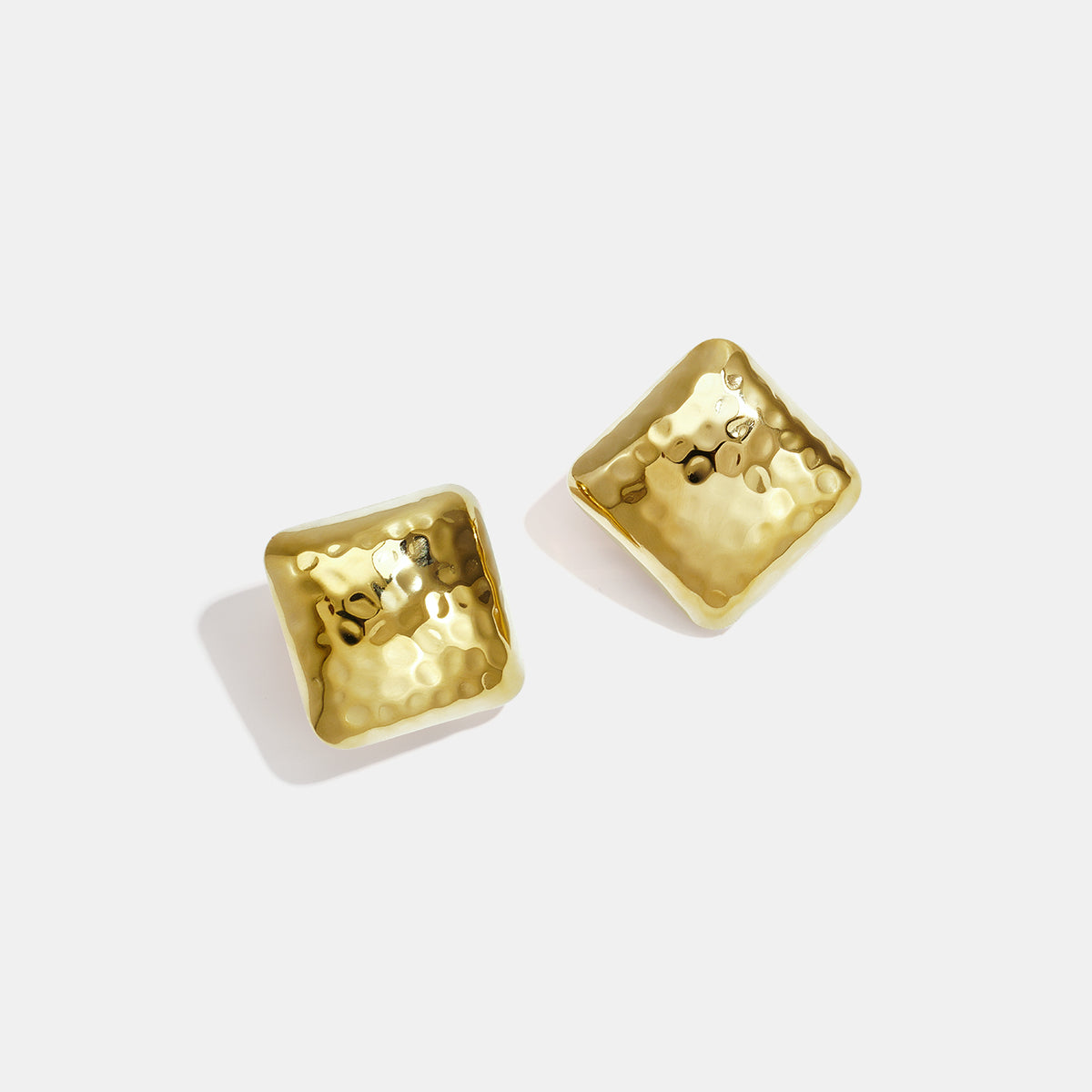 Gold Aurelia stud earrings with a hammered, square-like design.