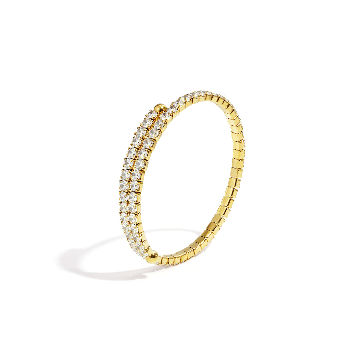 Gold cuff bracelet with two rows of clear rhinestones on a white background.