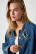 Gold leopard brooch with rhinestones on a denim jacket.