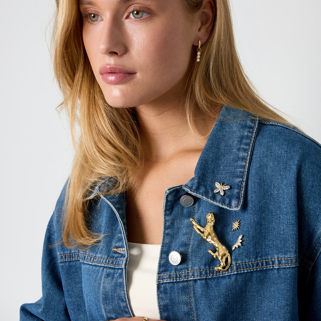 Gold leopard brooch with rhinestones on a denim jacket.