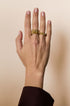 Gold-colored irregular minimalist ring on a hand.