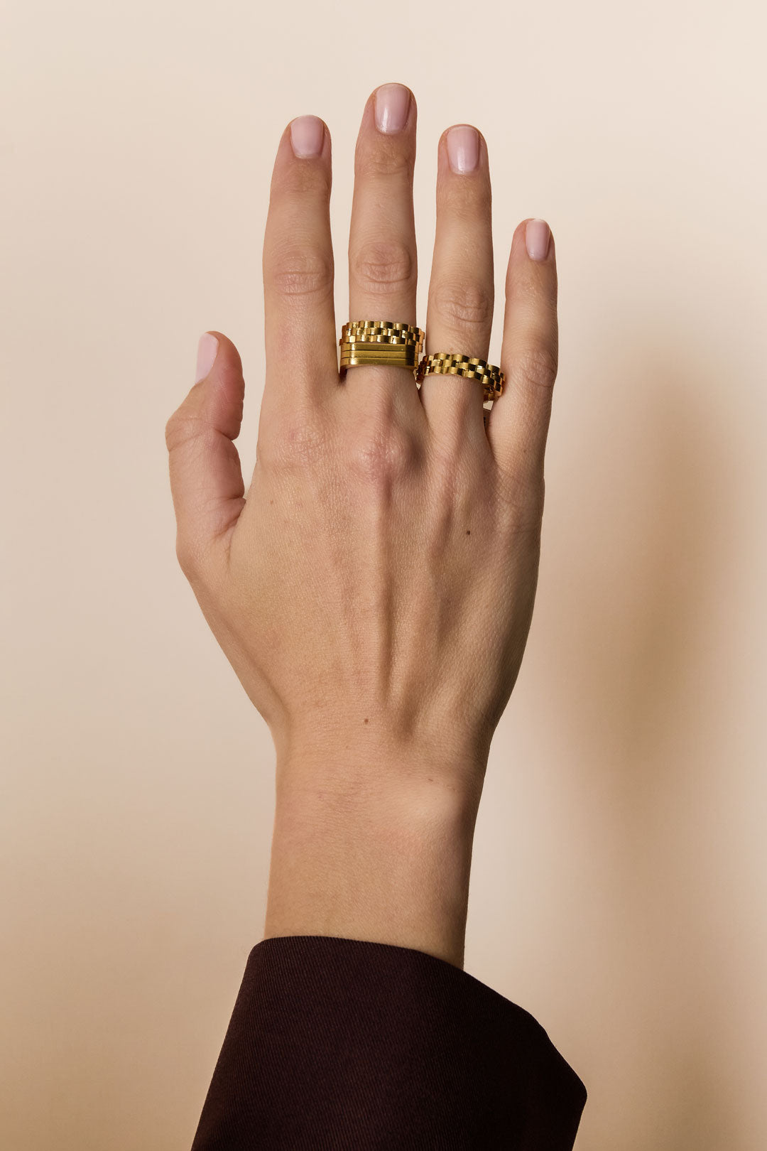 Gold-colored irregular minimalist ring on a hand.