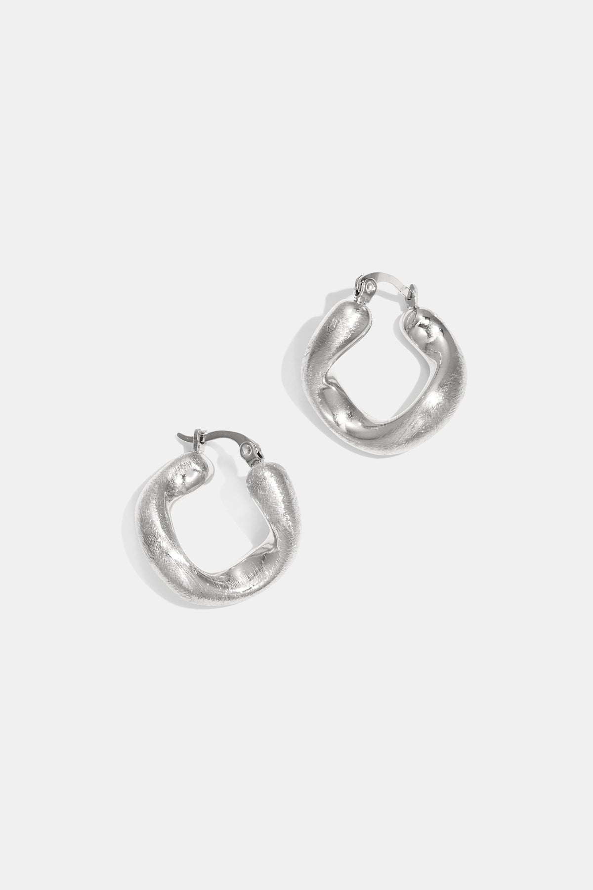 A pair of silver irregular circle hoop earrings with a textured finish, displayed on a white background.