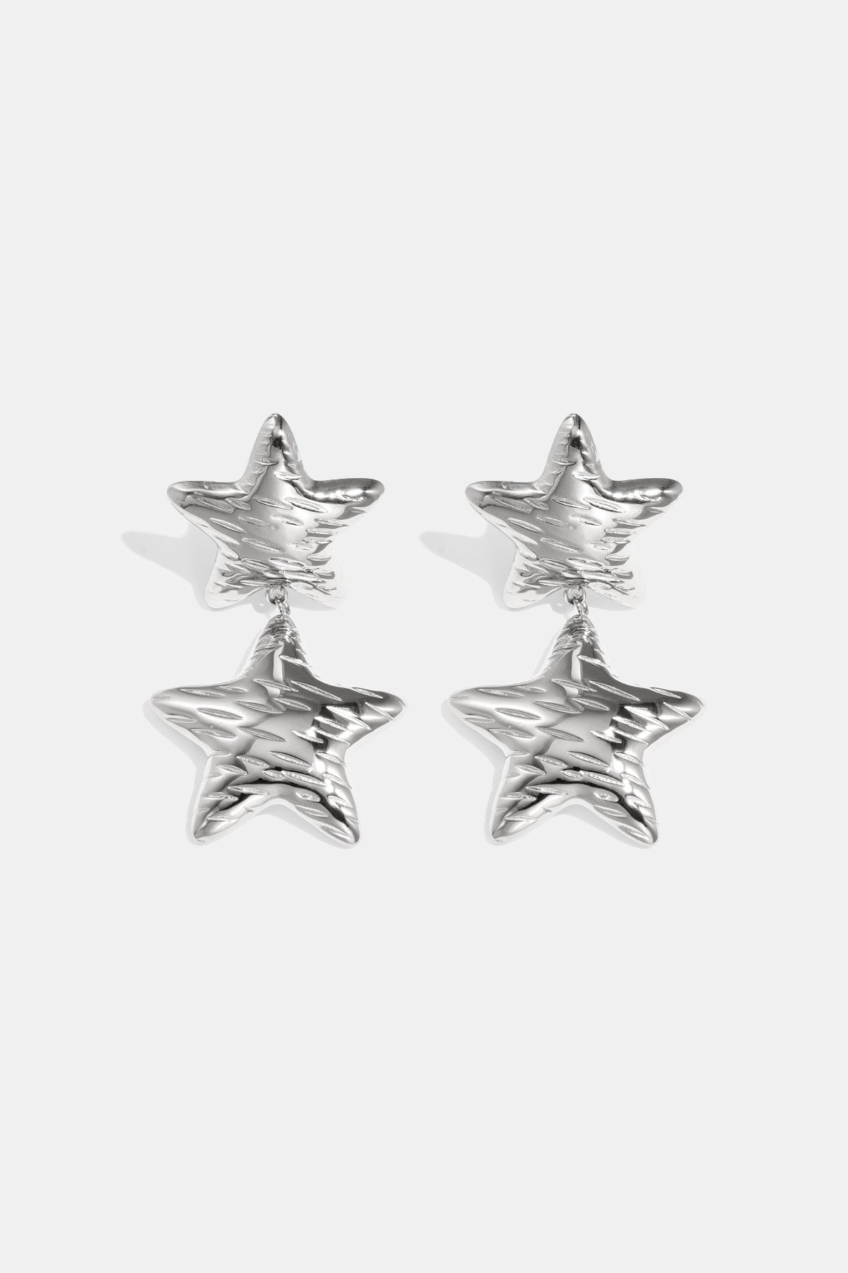 Silver celestial star drop earrings with textured surface.