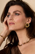 Gold circular Aura statement earrings with a textured finish.