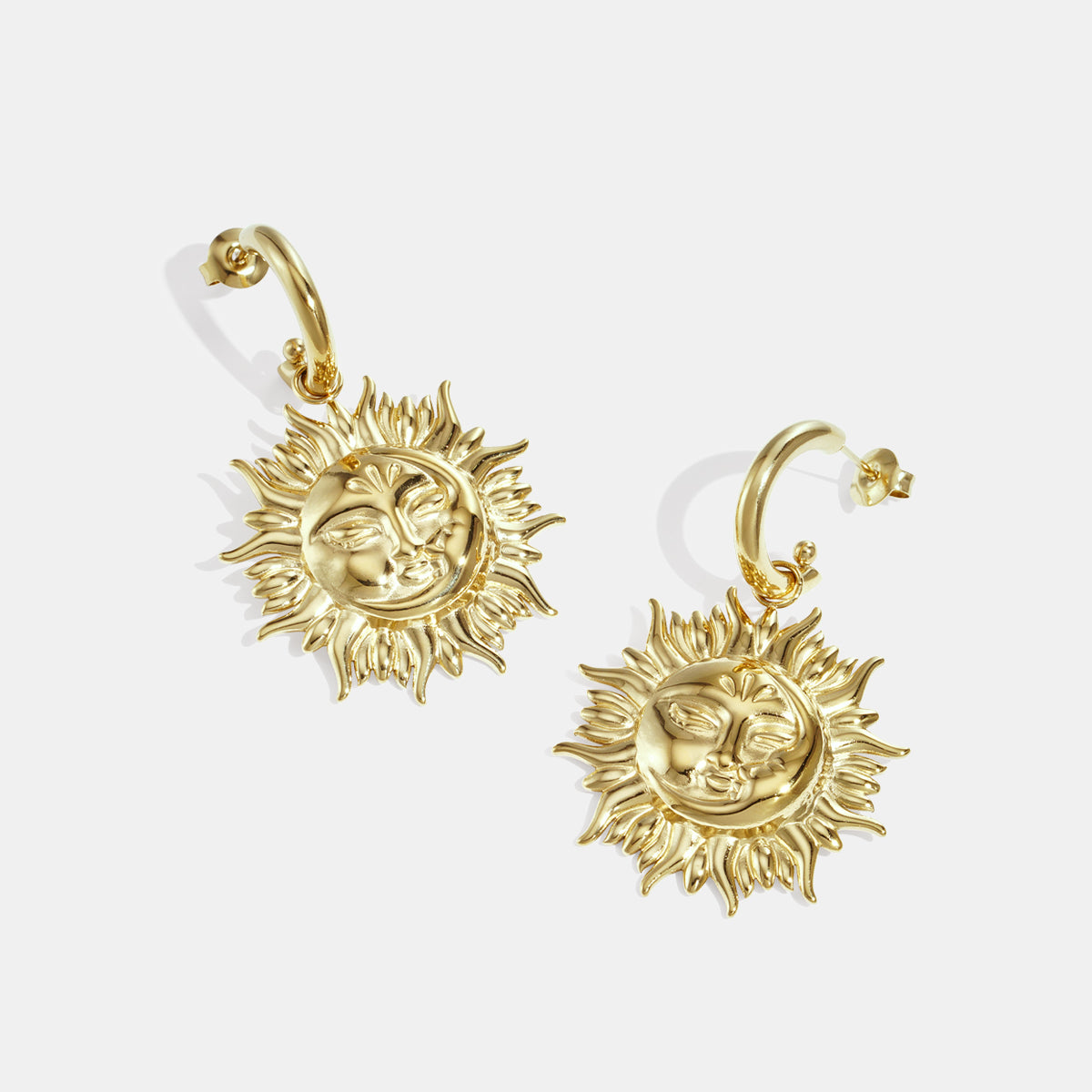 Gold-toned hoop earrings with dangling sun face charms.
