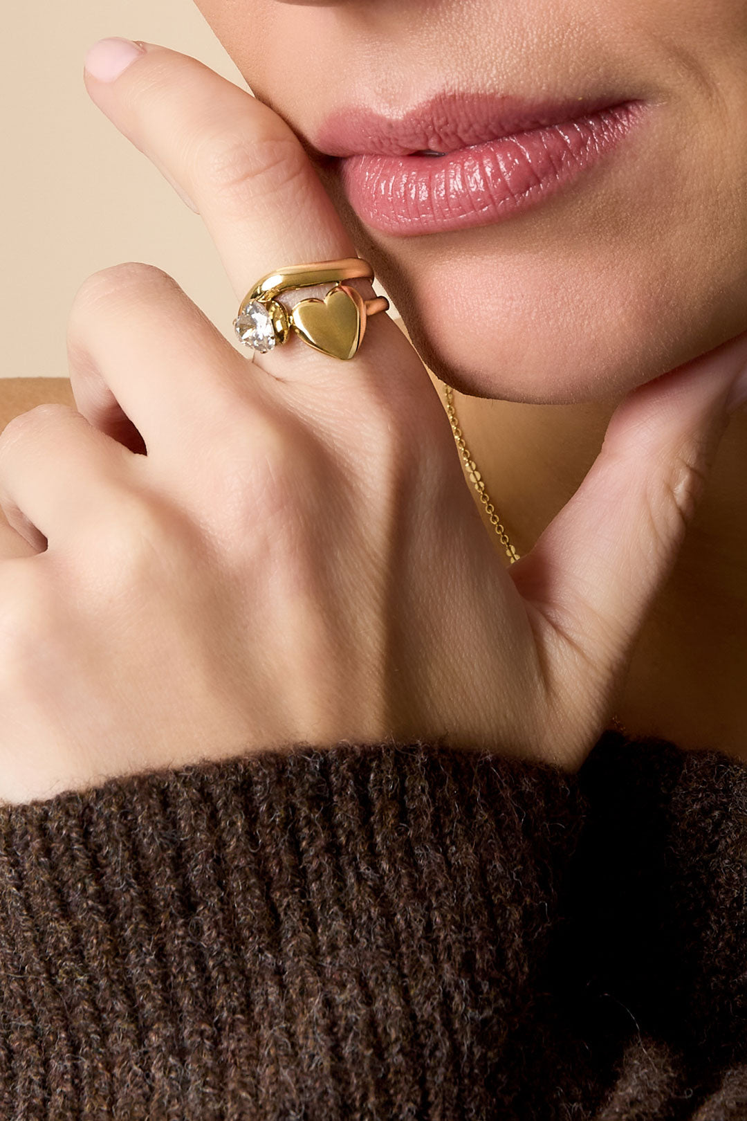 Gold ring with a heart shape and a zircon gemstone.