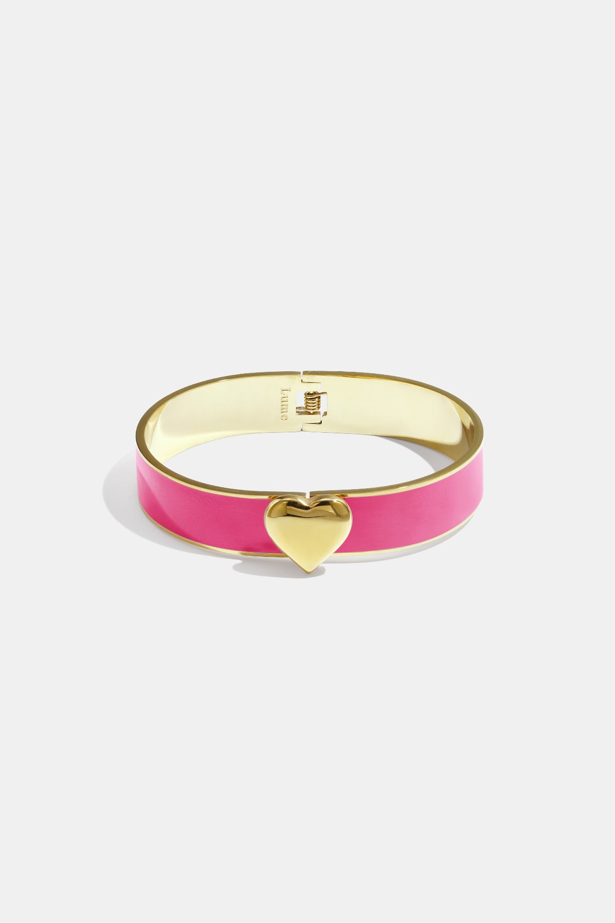 Gold bangle bracelet with a pink enamel band and a gold heart charm.