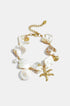 Ocean Charm Bracelet with shell, starfish, and pearl charms on a gold chain.