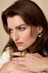 Gold statement ring with a pearl accent on a woman's hand.