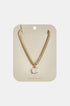Gold snake chain necklace with a square-cut clear pendant on a beige card.