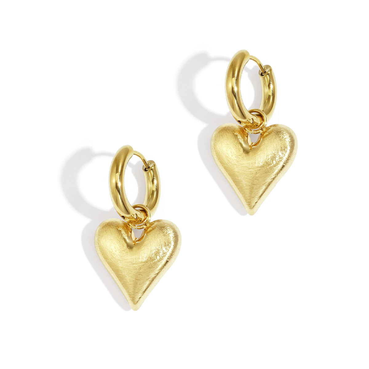 Gold heart drop earrings with a brushed finish on a white background.