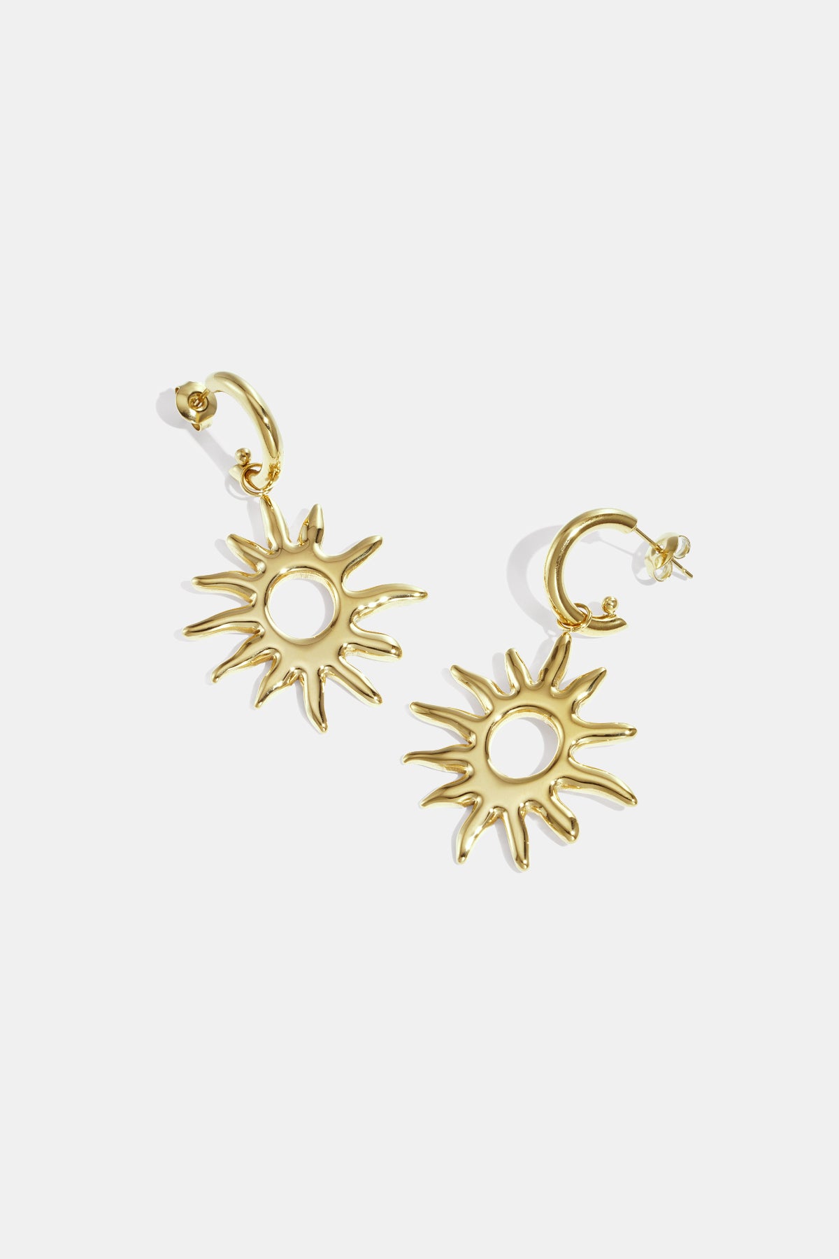 Gold-toned sun-shaped drop earrings with pointed rays and a circular center.