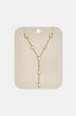 Gold necklace with five clear stones arranged in a Y-shape on a beige card.