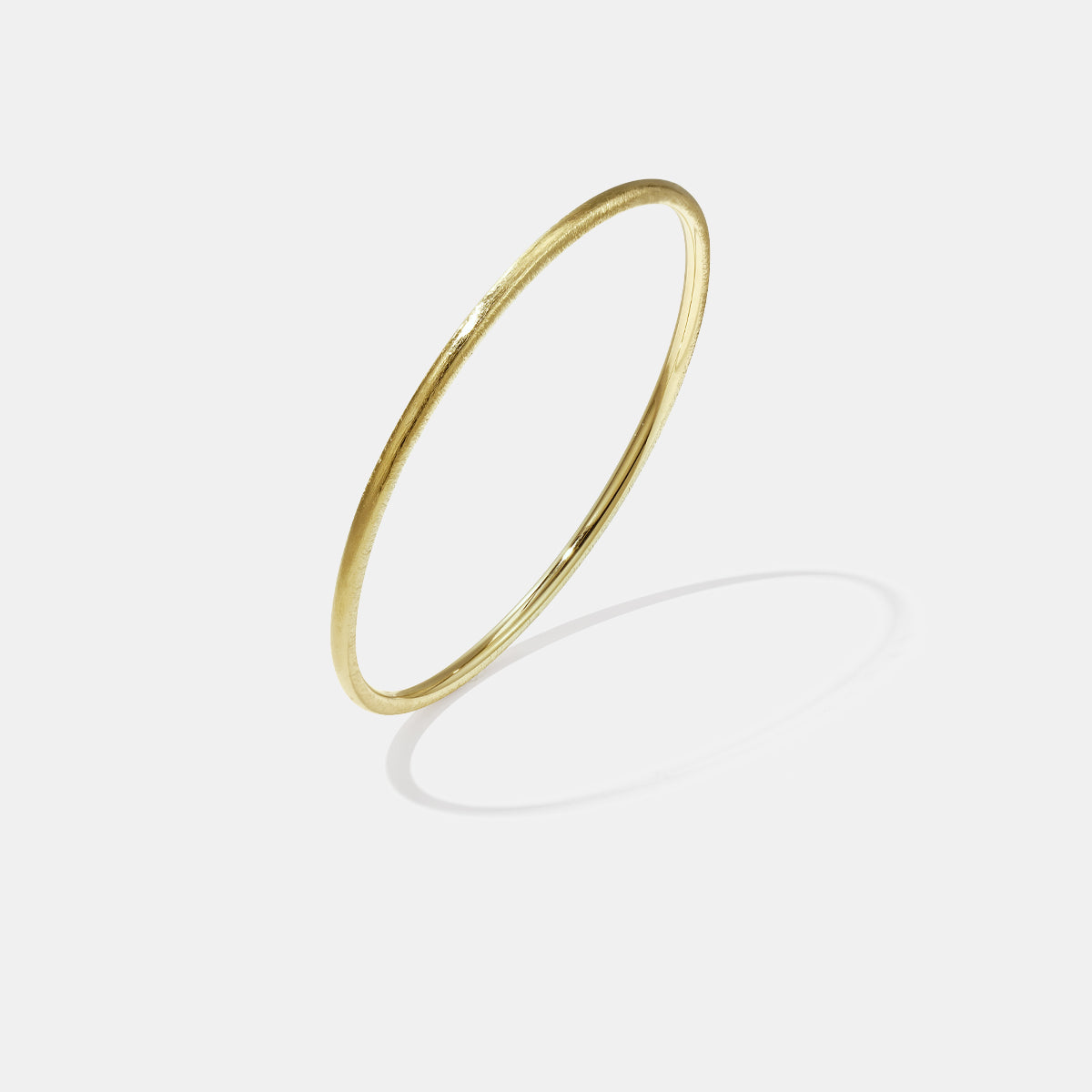 Gold-toned 3 mm wide brushed finish bangle bracelet with a subtle texture.