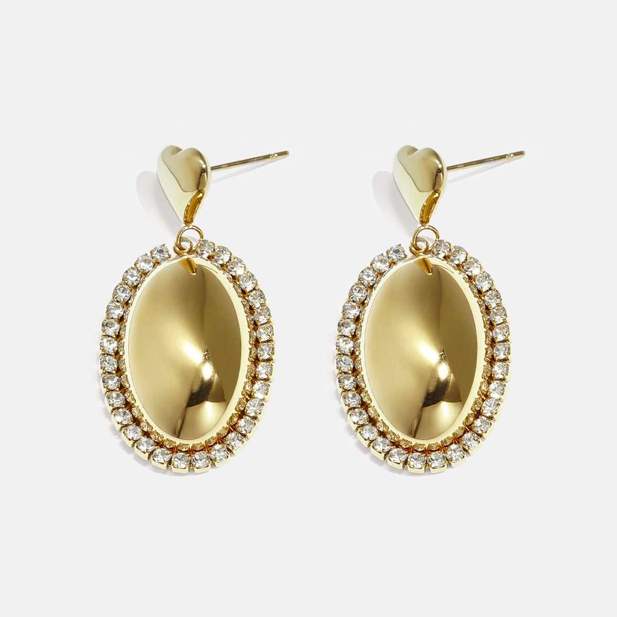 Gold oval earrings with rhinestones and heart-shaped studs.