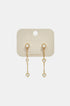Gold dangle earrings with heart-shaped zircon charms hanging from a bar.