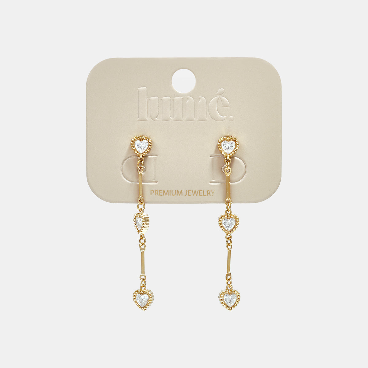Gold dangle earrings with heart-shaped zircon charms hanging from a bar.