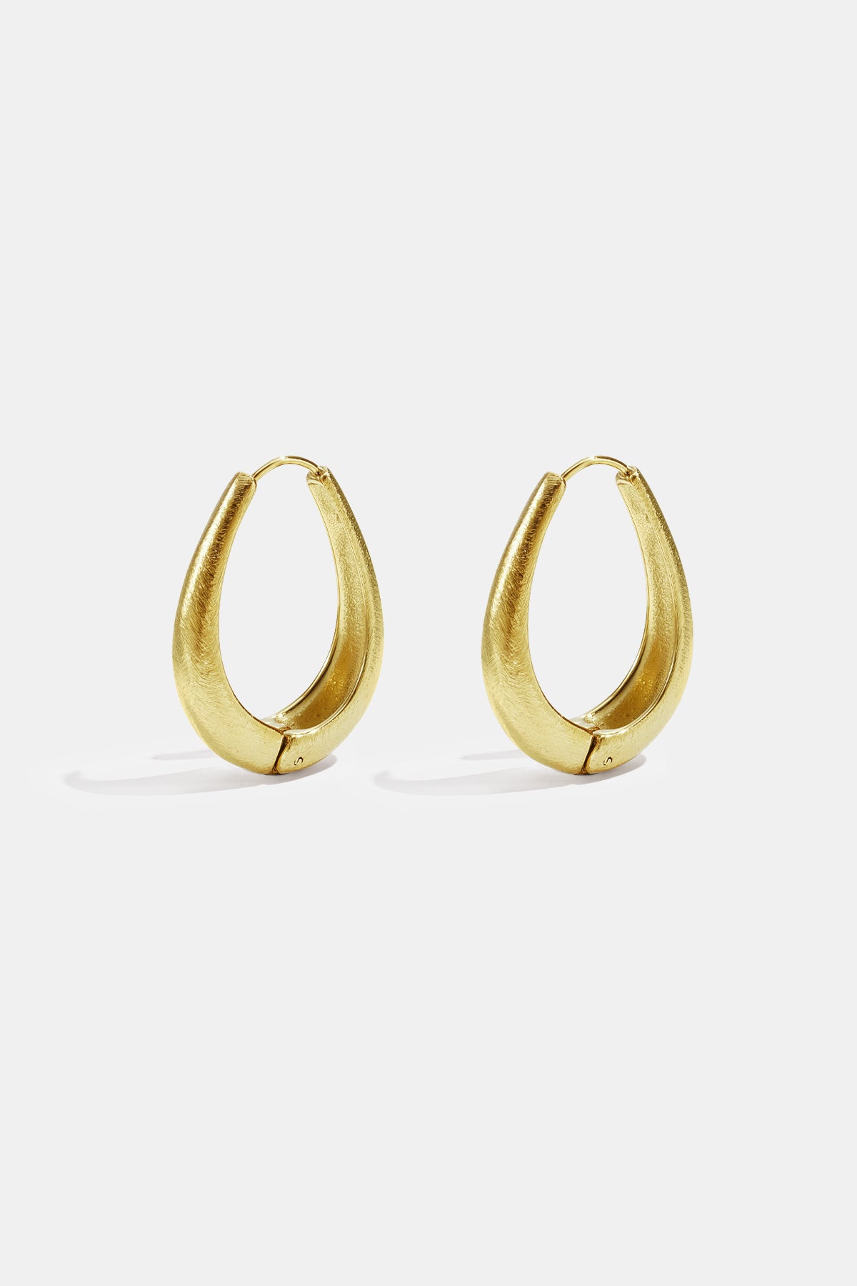 Gold irregular oval hoop earrings with a brushed finish.